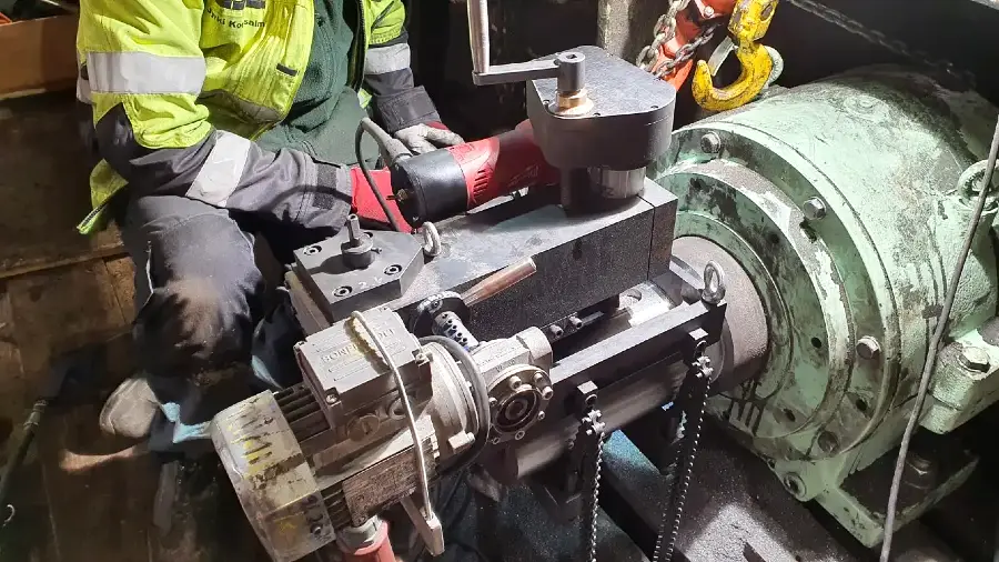 Technician performing on-site shaft machining with portable equipment